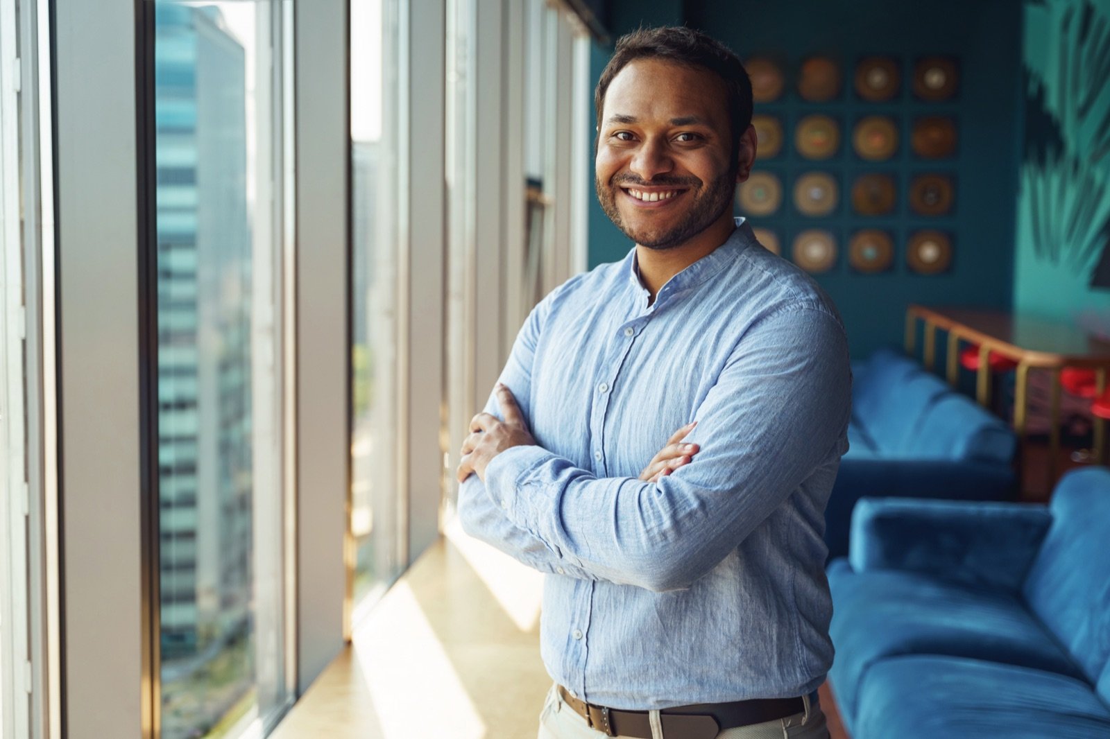 Smiling entrepreneur standing confidently in a bright workspace